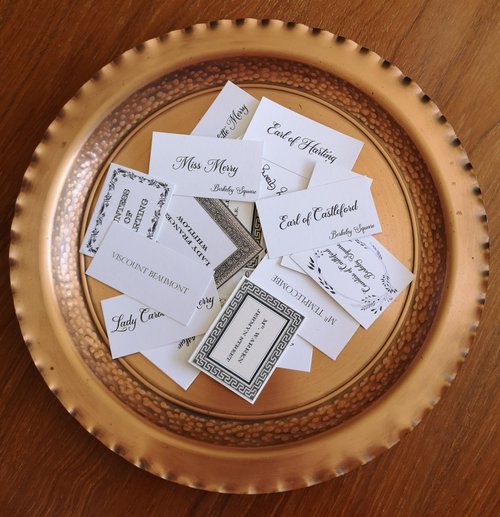 A golden round tray containing a bunch of calling cards