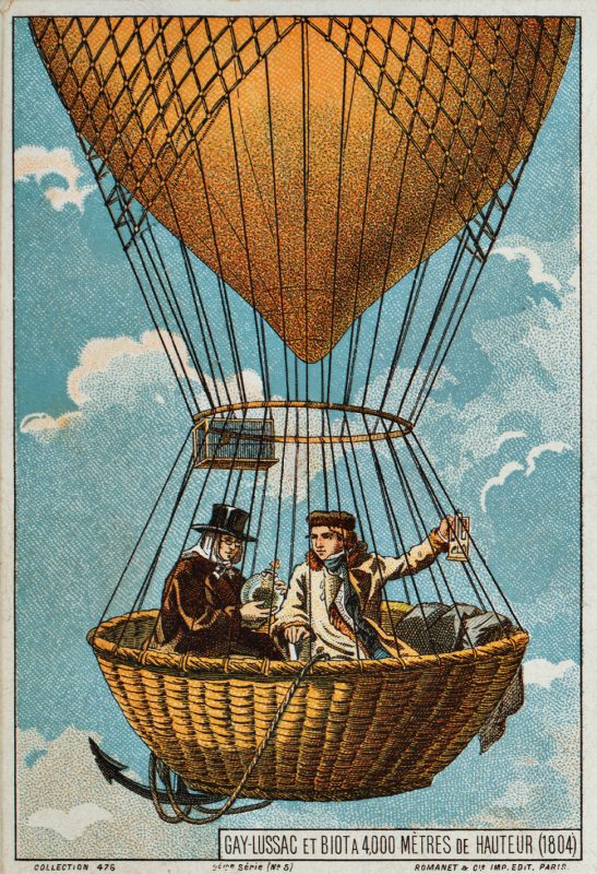 An image of a couple of men riding in the skies on a hot air balloon.