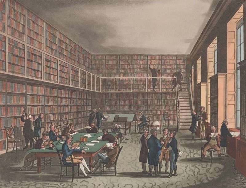 Inside a Regency era circulating library with walls filled with books and some people reading at a table and others chattering around.