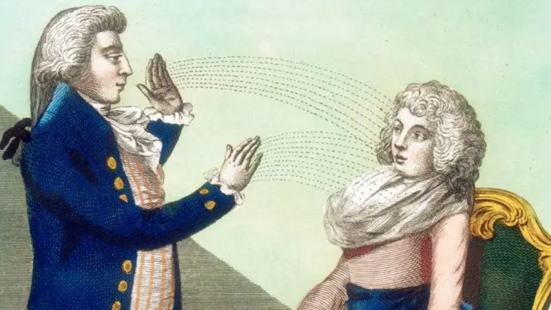 An image of a man seemingly hypnotising the woman in front of him.