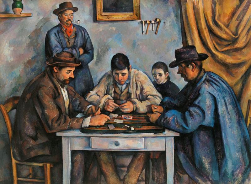 A few men sitting around a table playing cards.