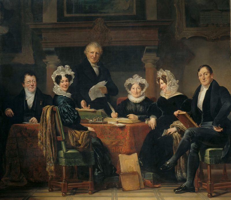 A group of men and women seated at a table having a meeting.