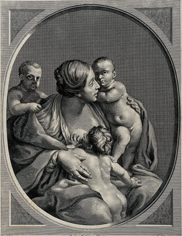 A woman breastfeeding one of his sons while holding another and a third one on her back.